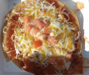 An actual Taco Bell Mexican Pizza served with its signature layers of tortillas, beans, beef, cheese, tomatoes, and sauce